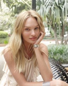 a beautiful blonde woman sitting on top of a bench