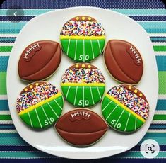 decorated cookies with footballs and sprinkles on a plate