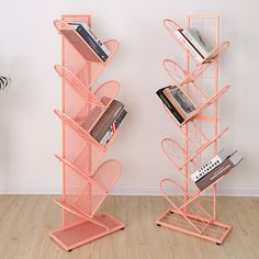 two orange bookshelves on wooden floor next to white wall