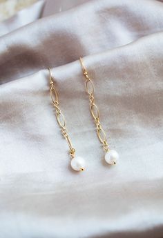 This listing is for a pair of freshwater pearl and 14k gold filled earrings. All gold accessories are 14k gold filled. The white freshwater pearls measure 6 mm. These earrings are 1.5 inches long. Perfect for everyday wear, weddings, gifts, and more! Please check out the matching freshwater pearl and 14k gold filled necklace here -https://wildcollections.etsy.com/listing/668016373 Please check out the matching freshwater pearl and 14k gold filled bracelet here -  https://wildcollections.etsy.com/listing/649806865 14k Yellow Gold Filled Dangle Pearl Earrings, 14k Gold Filled Pearl Chain Earrings As Gift, 14k Gold Earrings With Pearl Chain For Gift, 14k Gold Pearl Chain Earrings As Gift, 14k Gold Filled Pearl Earrings With Pearl Chain, Gold 14k Gold-filled Pearl Chain Earrings, Dainty Gold Linear Earrings With Pearl Charm, Delicate Gold Linear Earrings With Pearl Drop, Gift Yellow Gold Linear Earrings With Pearl Charm