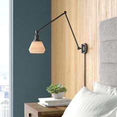 a bedroom with a bed and a lamp on the wall next to it's headboard