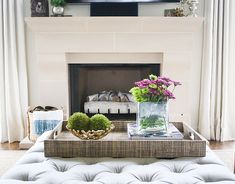 a living room with a couch, coffee table and television on the fireplace mantel