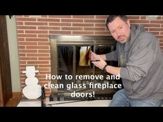 a man kneeling down in front of a fire place with a glass door on it