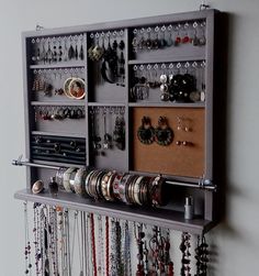 a wall mounted jewelry rack with lots of bracelets and rings on it's sides