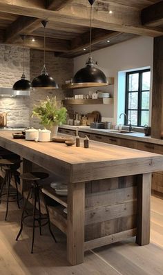 a large kitchen island with stools next to it and lights hanging from the ceiling