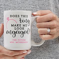 a woman holding a coffee mug with the words does this ring make me look engaged?