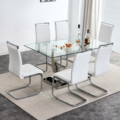 a glass dining table with white chairs and a bottle of wine on the rug next to it