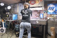 a woman standing in front of a workbench