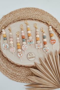 a table topped with lots of different types of beads and key chains on top of a straw hat