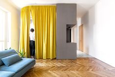 a living room filled with furniture and yellow drapes