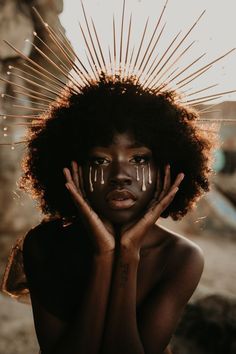 a woman with her hands on her face and sunbeams coming out of her hair