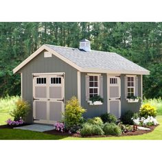 a gray shed with windows and flowers in the yard