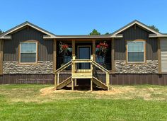 the front of a mobile home with stairs leading up to it's second story