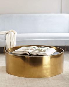 a living room with a white couch and gold coffee table