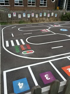 an outdoor play area with painted numbers on the ground and parking spaces for children to play in