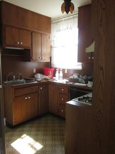 a kitchen with wooden cabinets and tile flooring in the sun shining through the window