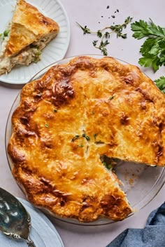 a pie on a plate with a slice missing from it next to a fork and knife