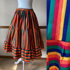 Gorgeous full circle rainbow skirt from the 70s! Pictured with a petticoat, not included -The only tag has a handwritten 30 on it -This feels like a cotton poly blend -Would fit a size small, 23" to 27" waist (maybe a tight 28") -Length: 29.5" Each side of the waist ties, so the waist is adjustable.  The ties can either be tied at the sides, or can be wrapped around each way and tied in the front and in the back.  There is no elastic and no other closures besides the ties.  The skirt is unlined. Very good vintage condition!  Clean and ready to wear. The only thing to note is light marking on part of the ties, but it's very faint and won't be seen when worn and ties are tied. This skirt is a wonderful piece and the colors are incredibly vibrant! All vintage items are unique and pre-loved, a Retro Full Skirt Petticoat With Ruffles, Vintage Long Skirt Petticoat, Spring Retro Petticoat, Vintage Tiered Skirt Bottoms For Festival, Vintage Cotton Flared Skirt Bottoms, Vintage Cotton Flared Skirt, Retro Skirted Cotton Bottoms, Retro Fitted Skirt For Festival, Vintage Skirted Petticoat With Lined Skirt