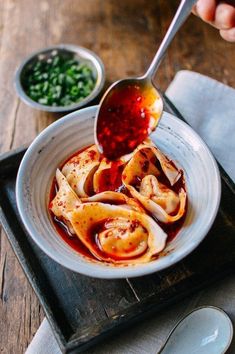 someone is dipping sauce on some food in a bowl