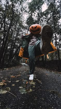 a person wearing a jack - o'- lantern costume is walking down the road