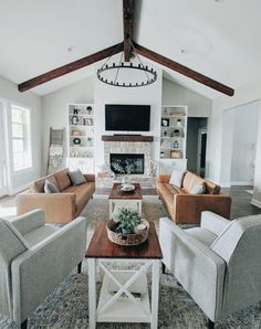 a living room with couches, chairs and a tv on the wall in it