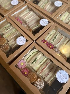 many different types of sandwiches in boxes on a table