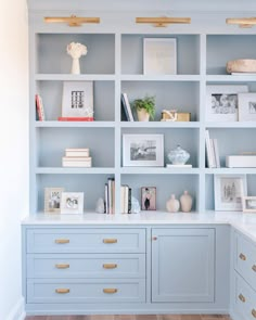 a blue bookcase filled with lots of books next to a white counter and drawers