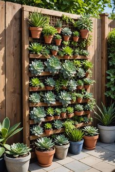 many potted succulents are arranged on the side of a wooden fence