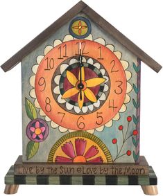 a clock with flowers painted on it and the words live by the sun or love by the moon