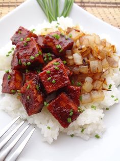 a white plate topped with rice and meat