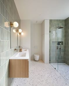 a bathroom with two sinks, a toilet and a walk in shower stall next to each other