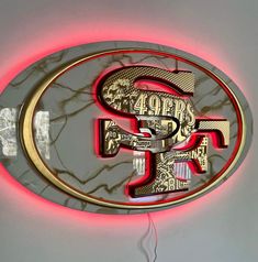 a lighted sign with the word san francisco in gold and red letters on a white wall