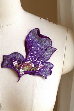 the back of a mannequin's torso with purple fabric and sequins on it