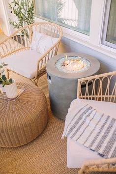 two wicker chairs sitting next to each other in front of a fire pit on the floor