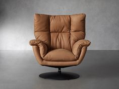 a brown leather reclining chair sitting on top of a black metal base in an empty room