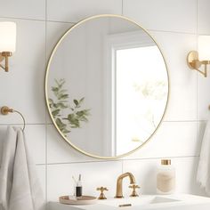 a bathroom with a sink, mirror and towels hanging on the wall next to it