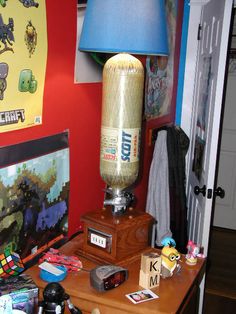 a lamp on top of a wooden table next to a computer monitor and other items