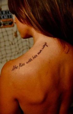 the back of a woman's shoulder with an inscription that reads she flies with her wings