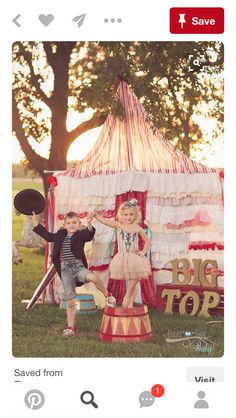 two young children standing in front of a circus tent