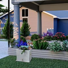 an outdoor garden with flowers and plants on the grass in front of a blue house