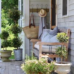 a porch with potted plants and hanging baskets