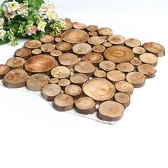 several pieces of wood sitting next to each other on a white surface with flowers in the background