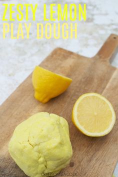 a wooden cutting board topped with lemons next to a sliced lemon on top of a table