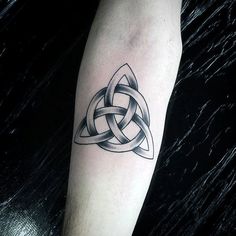 a black and white photo of a celtic tattoo on the left arm with an intertwined design