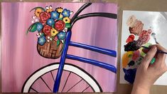 a person is painting flowers in a basket on a bike with paint and watercolors