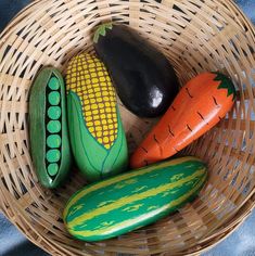 some vegetables are sitting in a basket on a blue cloth and it looks like they have been painted