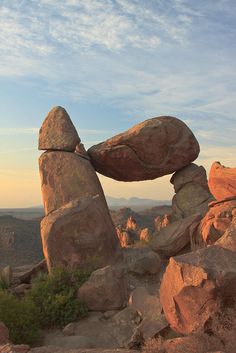 the large rocks are balanced on top of each other in order to form an arch