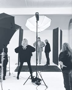 a group of people standing in front of a camera set up for a photo shoot