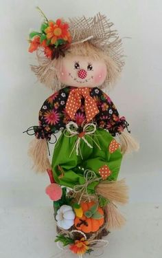 a stuffed doll is sitting on top of a basket filled with flowers and carrots