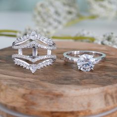 two wedding rings on top of a wooden board